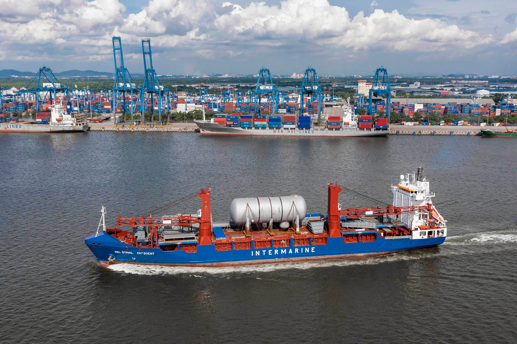 aerial of loaded heavy lift ship leaving port aerial shipping